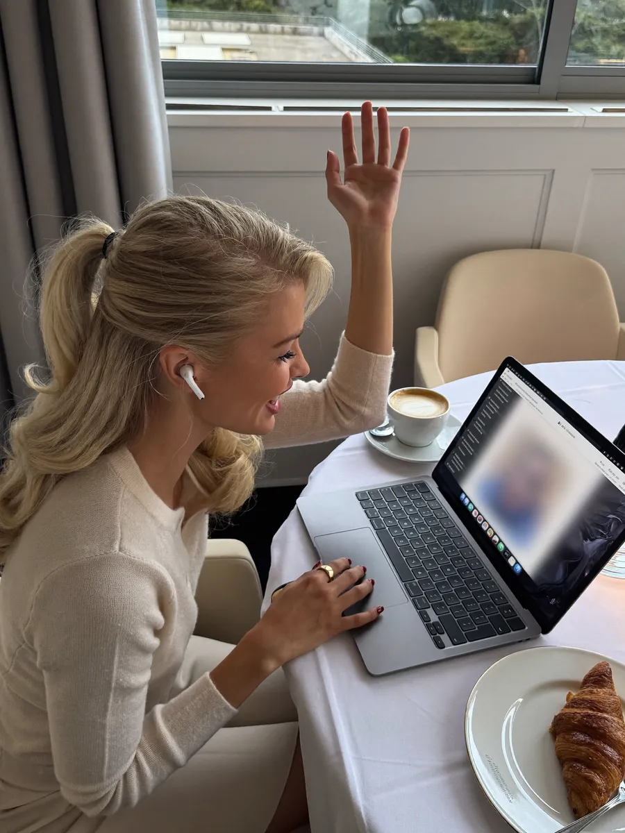 Waving into a video call over a hotel breakfast (illustrative)